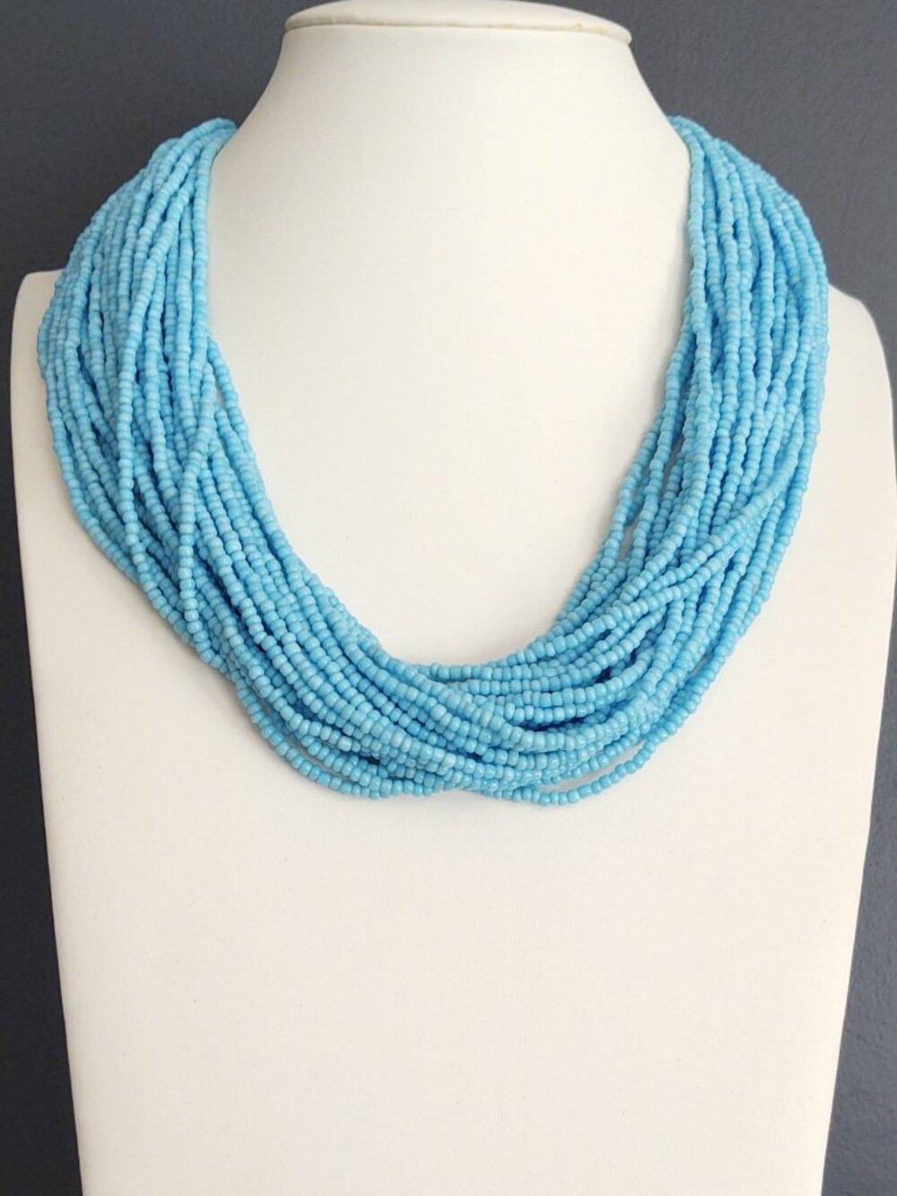 Layered blue beaded necklace with old coin toggle closure